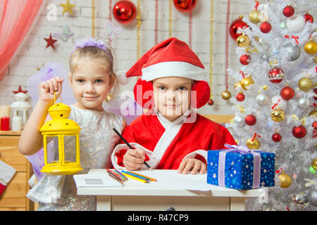 Father Frost wrote a congratulatory letter to the assistant fairy standing next to a candlestick in his hand Stock Photo