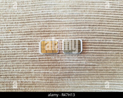 two micro sim cards on a wooden surface background Stock Photo