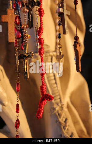 Rosaries hung on a religious status as a request for something at Our Lady of Guadalupe Shrine, frequented by Hispanics and immigrants, located in Des Plaines, Illinois. Stock Photo