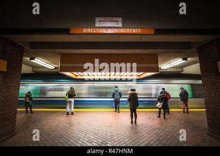 MONTREAL, CANADA - NOVEMBER 3, 2018: People waiting for a subway in Snowdon station platform, orange line, while a metro train is coming, with a speed Stock Photo