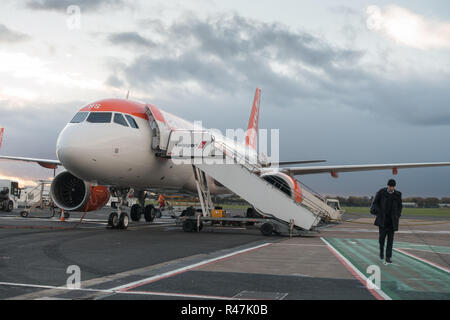 Lone male passenger disembarking an Easyjet flight 319 aircraft at Belfast International Airport on a cold grey overcast autumn day. Stock Photo