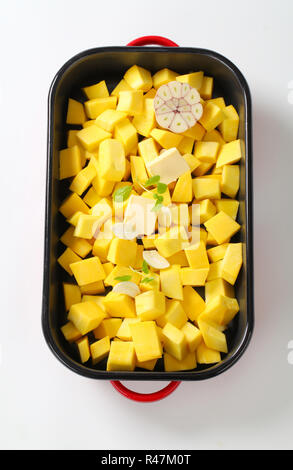 diced pumpkin with butter and garlic in a baking pan Stock Photo