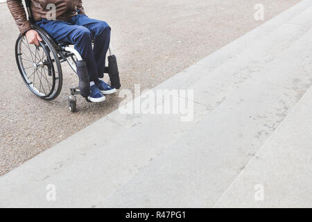 Man in wheelchair in front of stairs. Stock Photo