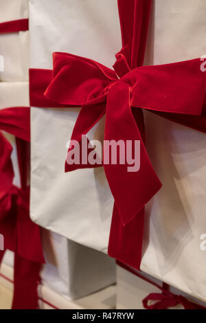 Wrapped present. White box with red velvet ribbon, photographed at VV Rouleaux haberdashery shop, Marylebone Lane, London, UK. Stock Photo