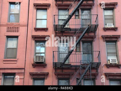 Fire Escape Steel Ladder on Urban Red House Facade Stock Photo