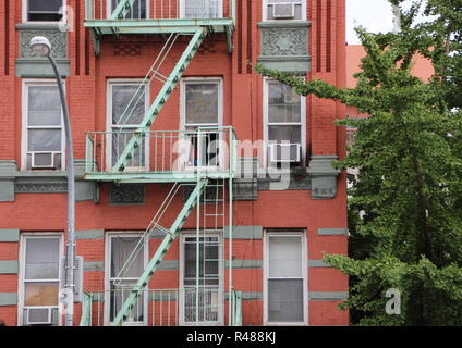 Green Metal Fire Escapes on Old Red Building Stock Photo
