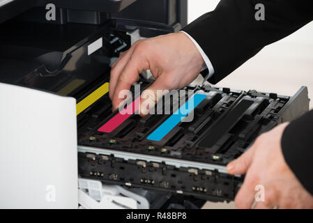 Businessman Fixing Cartridge In Photocopy Machine Stock Photo