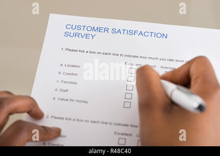 Person Filling Customer Satisfaction Form Stock Photo