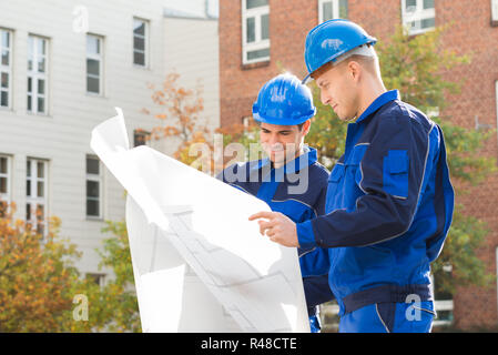 Architects Analyzing Blueprint Together Stock Photo