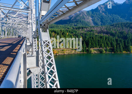 The truss Bridge of God over the Columbia River is located in a picturesque area of Columbia Gorge with hills and rocky mountains forest covered - an  Stock Photo