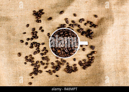 Coffee beans in a mug on a brown, structured background Stock Photo
