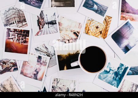 A mug with coffee standing between a bunch of polaroids Stock Photo