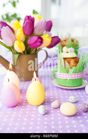 Easter cake and bouquet of yellow tulips on the tableEaster cake and ...
