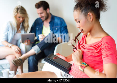 Young business woman using her tablet, in the background the business people use tablet too. Stock Photo