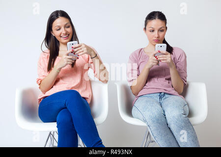 Beautiful young woman using her mobile phone at home. Stock Photo