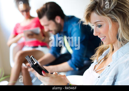 Young business woman using her tablet, in the background the business people use tablet too. Stock Photo
