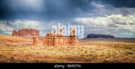 Panoramic view of stunning Hoodoos sandstone formations in famous Goblin Valley State Park on a beautiful sunny day with dark clouds and thunderstorm  Stock Photo