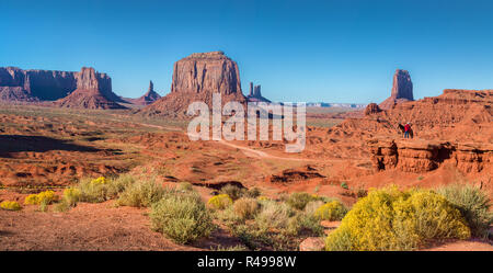 Classic panoramic view of scenic Monument Valley with horse rider at famous John Ford's Point  in beautiful golden evening light at sunset in summer Stock Photo