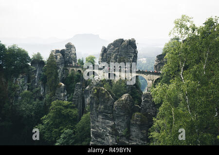 Beautiful panoramic view of famous Bastei Bridge with Elbe Sandstone mountains in Saxon Switzerland National Park on a moody day, Saxony, Germany Stock Photo