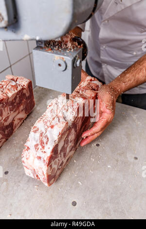 Industrial food processing machine cutting frozen pork chops Stock Photo