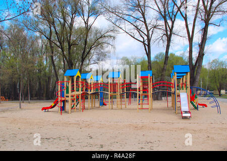 Childish playground in city park. Swing carousel in park for children. Children's playground bright multicolored. Modern playground for kids in city p Stock Photo