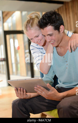 Students in school hallway using digital tablet Stock Photo
