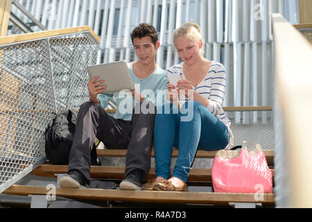 Students in school yard using digital tablet Stock Photo