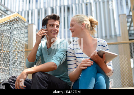 Students in school yard using digital tablet Stock Photo