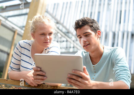 Students in school yard using digital tablet Stock Photo