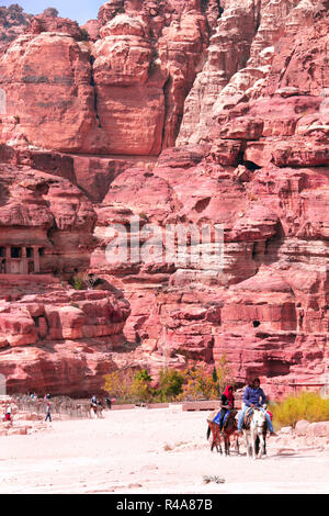 Tourists ride on donkeys in Petra (Red Rose City), Jordan. UNESCO world heritage site Stock Photo