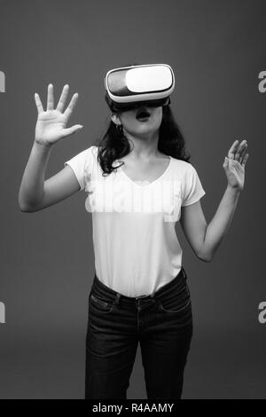 Young beautiful Asian woman using virtual reality glasses Stock Photo