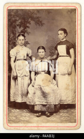 Original and rare Victorian Carte de Visite (CDV) 1800's  studio portrait of group of 3 poor looking Lancashire cotton mill girl workers wearing clogs and dirty aprons from the studios of Albert Parker, Blackpool, Lancashire, England, U.K. circa 1870's Stock Photo