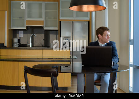 Young handsome businessman sitting in the dining room near the k Stock Photo