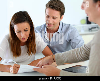 Couple signing real-estate contract Stock Photo