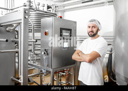 Worker operating pasteurizer using the control panel at the cheese or milk manufacturing Stock Photo