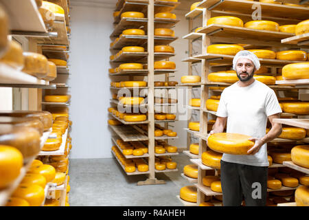 https://l450v.alamy.com/450v/r4aheh/man-storage-with-shelves-full-of-cheese-wheels-during-the-aging-process-r4aheh.jpg