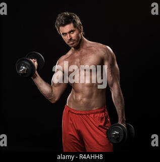 Sport, bodybuilding, fitness and people concept - man with dumbbells flexing muscles isolated on black background Stock Photo