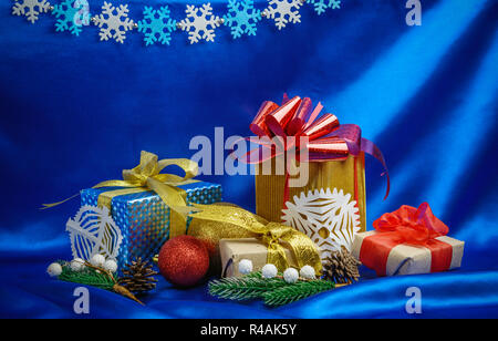 Christmas gift boxes and decorations over blue silk background Stock Photo