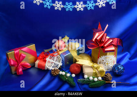 Homemade Christmas gift boxes and decorations over blue silk background Stock Photo