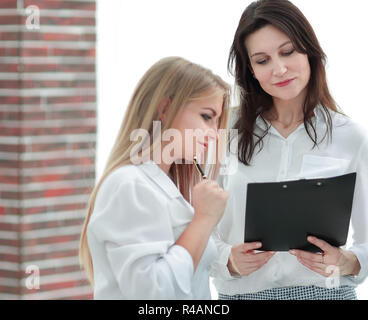 business colleagues looking at business documents standing in the office. Stock Photo