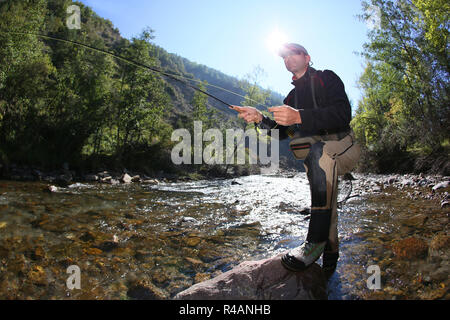 Fly fisherman using flyfishing rod in beautiful river Stock Photo