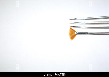 Drawing tools, set of dirty paint brushes in row on white isolated background, copy space, top view Stock Photo