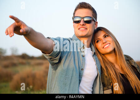 Portrait of happy young couple in field. Stock Photo