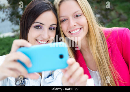 Two friends taking photos with a smartphone Stock Photo