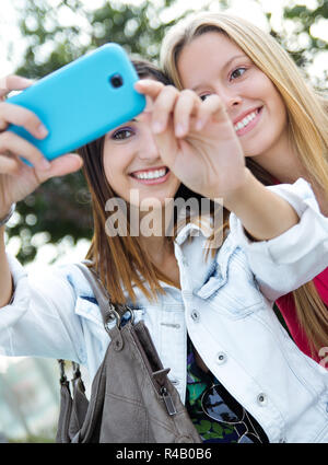 Two friends taking photos with a smartphone Stock Photo