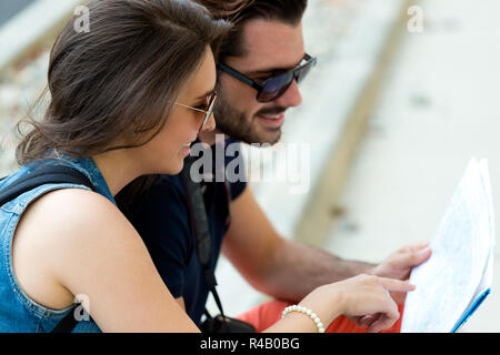 Young tourist couple in town holding a map. Stock Photo