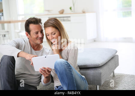 Middle-aged couple websurfing with tablet at home Stock Photo