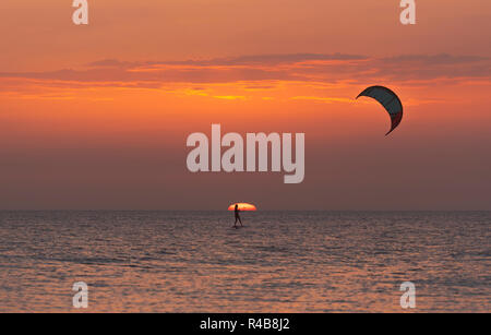 Kitesurfing on a foil at sunset. Tarifa, Costa de la Luz, Cadiz, Andalusia, Spain. Stock Photo