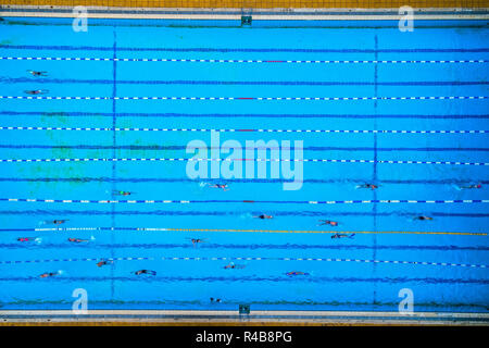 Aerial view of swimming pool with marked lanes and swimmers Stock Photo