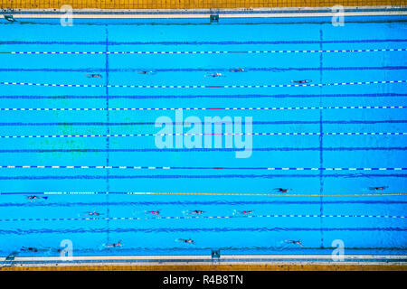 Aerial view of swimming pool with marked lanes and swimmers Stock Photo